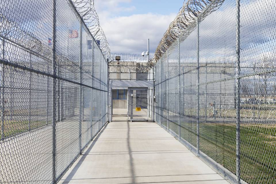 Chain link fence with a concertina topping is installed along the prison.
