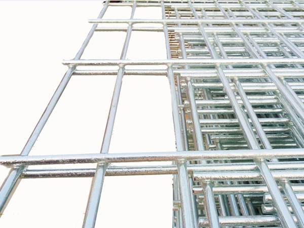 Many galvanized double wire fence panels are displayed.